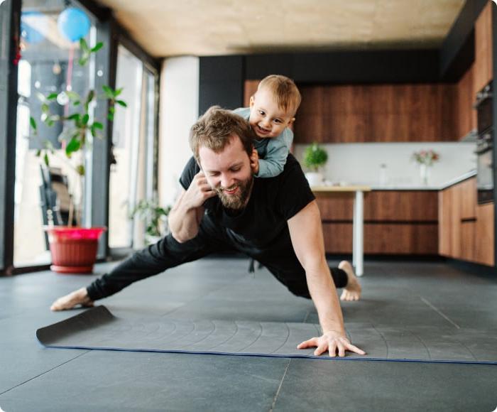 man doing a pushup with baby on his back